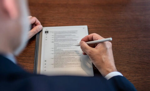 Mann im Anzug arbeitet mit einem Stylus auf einem digitalen Tablet mit einem Dokument zum Betriebsrentenstärkungsgesetz
